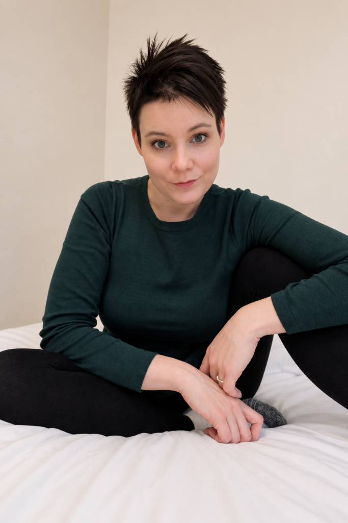 Raisa istumassa sängyllä